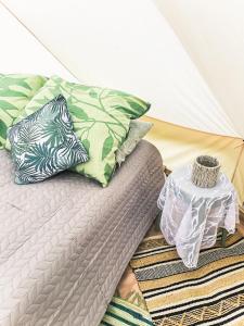 a bed with pillows on it with a tent at Lahemaa Nature Glamping - Koit in Vihasoo
