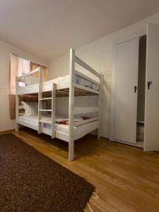 two white bunk beds in a room with a rug at APARTMENT Marash in Prizren