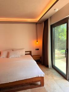 a bedroom with a bed and a large window at Life Butiq Otel in Yalıkavak