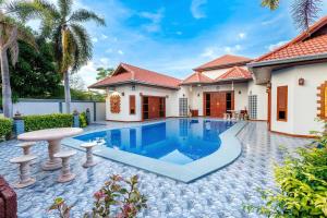 a villa with a swimming pool and a house at D Pool Villa Pattaya in Nong Prue