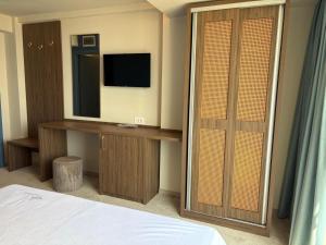 a bedroom with a bed and a television and a desk at Black Sea Resort in Eforie Sud