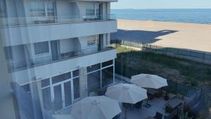 a balcony of a building with umbrellas and a beach at Black Sea Resort in Eforie Sud