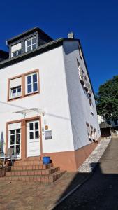 a large white house with stairs and a window at Ferienwohnung Talblick in Horath