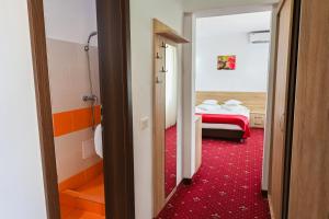 a room with a bed and a red carpet at Hotel Sallaris Monteoru in Sărata-Monteoru +27 photos