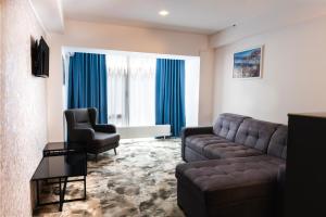 a living room with a couch and two chairs at Hotel Sallaris Monteoru in Sărata-Monteoru