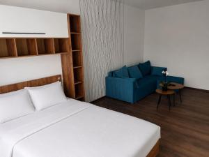 a bedroom with a bed and a blue chair at RUX Central Park in Petroşani +5 photos