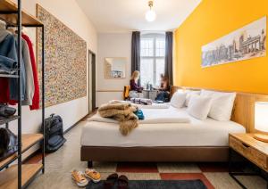 a hotel room with two beds and people sitting at a table at Three Little Pigs Hostel - Your Berlin Castle in Berlin
