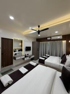 a large bedroom with two beds and a tv at Hotel Krishna Leela Lodging and Boarding in Bhusāwal