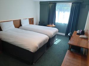a hotel room with two beds and a window at Legacy Preston International Hotel in Preston