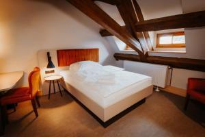 a bedroom with a bed and a table and a chair at Die Burg - Kurfürstlich Flämisch in Bad Belzig