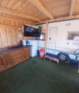 an rv with a kitchen and a tv in a room at Gästehaus Kathi GyenesCamping Wohnwagen Knaus 1 Rechts in Gyenesdiás