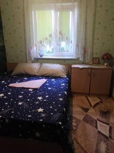 a bedroom with a bed and a window with stars at Кооператив Радуга in Rasseyka
