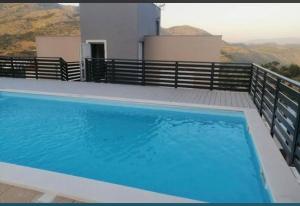 a large blue swimming pool on top of a house at Apartman Anela in Ivanica +5 photos