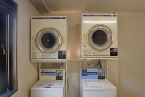 a laundry room with three washing machines and washers at Hakuba Yamano Hotel in Hakuba