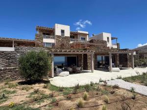 a large house with a patio in front of it at Soborgo Exquisite Villas in Tinos