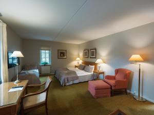 a hotel room with a bed and a chair at Milling Hotel Knudsens Gaard in Odense +200 photos