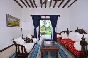 a living room with a couch and chairs and a table at Kasa Pomboo Hotel, Shimoni in Shimoni +106 photos