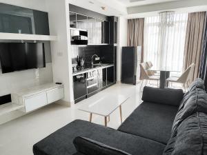 a living room with a couch and a tv at Modern and quiet Condo BKK1 - Rooftop Pool in Phnom Penh