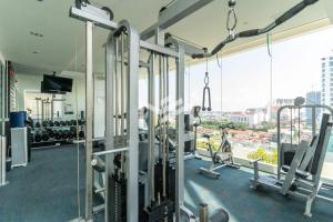 a gym with cardio equipment and a large window at Modern and quiet Condo BKK1 - Rooftop Pool in Phnom Penh