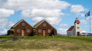 a wooden church with a lighthouse on a hill at Fjalladýrð Hotel in Modrudalur