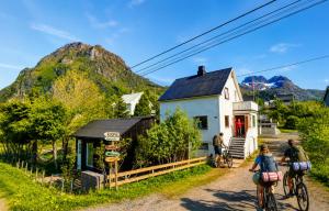 a group of people riding bikes in front of a house at Tiny House - The LOWFO House Lofoten in Moskenes