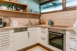 a kitchen with white cabinets and a sink at Chiemgau Nest II in Siegsdorf +8 photos