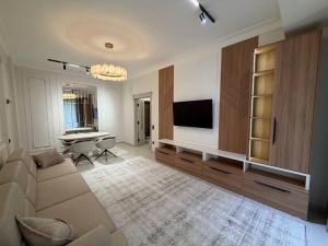 a living room with a couch and a flat screen tv at Top1 Gardens Residents in Tashkent +2 photos