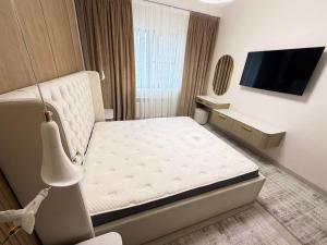a small bedroom with a bed and a tv at Top1 Gardens Residents in Tashkent