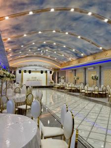 a banquet hall with tables and chairs and a dance floor at Mirali Resort in Almaty