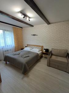 a bedroom with a large bed and a chair at Вершина Мрій in Slavske +9 photos