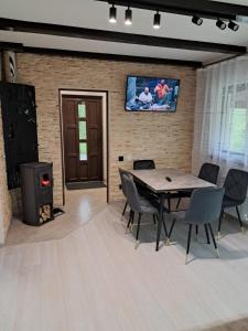 a room with a table and chairs and a tv at Вершина Мрій in Slavske