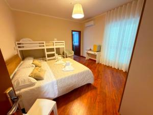 ein Schlafzimmer mit einem großen weißen Bett und Holzböden in der Unterkunft Suite 04 in Airola