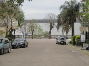 dwa samochody zaparkowane na parkingu obok jeziora w obiekcie Departamento en el centro de Colon w mieście Colón