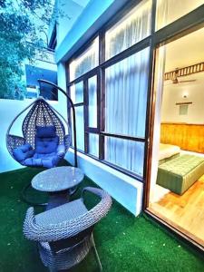 a porch with a swing and a table and chair at Desert Oasis Camp And Resort in ladakh