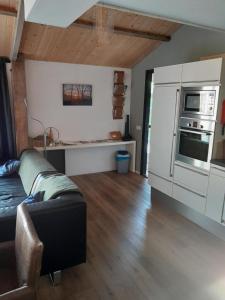 a living room with a couch and a kitchen at De Spaanse Ruiter in Leusden +5 photos