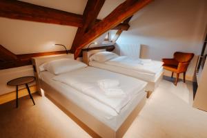 two beds in a small room with a chair at Die Burg - Kurfürstlich Flämisch in Bad Belzig +4 photos