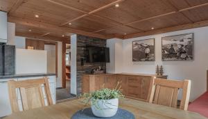 a kitchen and dining room with a wooden ceiling at Appartements Alpenrose in Längenfeld