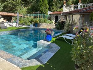 a swimming pool in a yard with a vase of flowers at Appartement design avec piscine in Digne-les-Bains