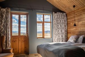 a bedroom with two windows and a bed in it at Fjalladýrð Hotel in Modrudalur +7 photos