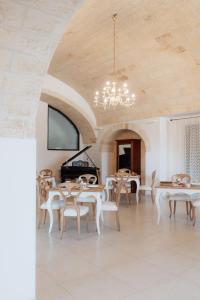 a room with tables and chairs and a piano at Masseria La Vecchia Lamia in San Vito dei Normanni
