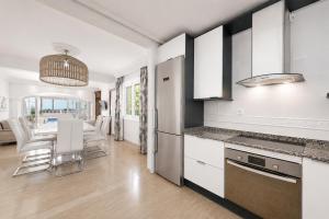a kitchen with white cabinets and a table with chairs at Villa Bruno in El Toro
