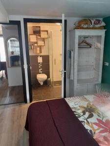 a bedroom with a bed and a bathroom with a toilet at De Spaanse Ruiter in Leusden