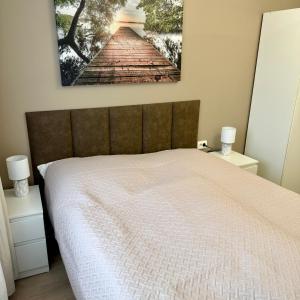 a bedroom with a bed with a painting on the wall at Theo in Poznań +16 photos