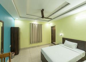a bedroom with a bed and a ceiling fan at Hotel Almora Palace in Almora +13 photos