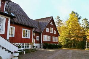 a large red house with white windows and a driveway at EFS-gården in Åsljunga