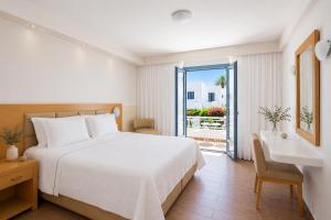 a bedroom with a white bed and a balcony at Lagos Mare Hotel in Agios Prokopios +122 photos