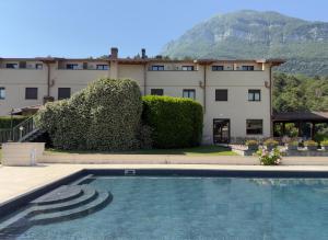 a hotel with a swimming pool in front of a building at Hotel Merloni in Grandola ed Uniti