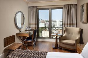 a hotel room with a bed and a desk and a window at Titanic City Taksim in Istanbul