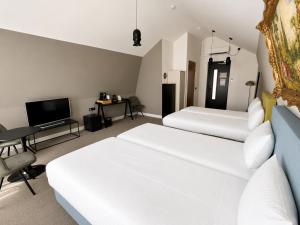 a hotel room with two beds and a television at Boutique Hotel Zaan in Zaandijk