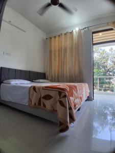 a bedroom with a bed and a ceiling fan at Guruji Homestay Near UPES Collage in Jhājra